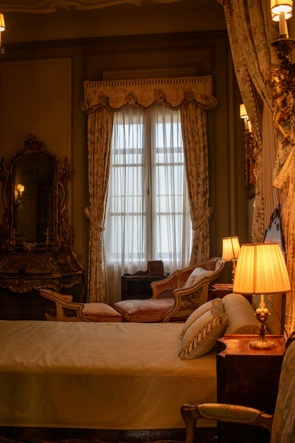 Una camera da letto lussuosa con copriletto color crema e arredi sontuosi.